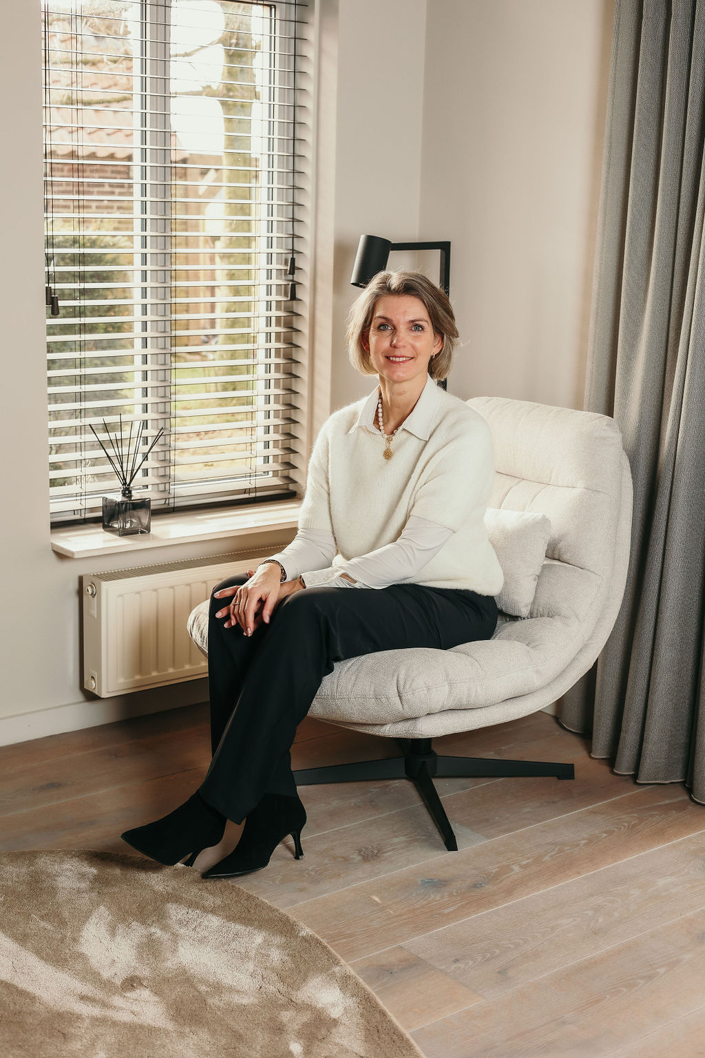 Dianne Verkerk Dianne Verkerk – coach en HR-professional, zittend in een rustige praktijkruimte, klaar voor een persoonlijk gesprek over werk en leven in balans.